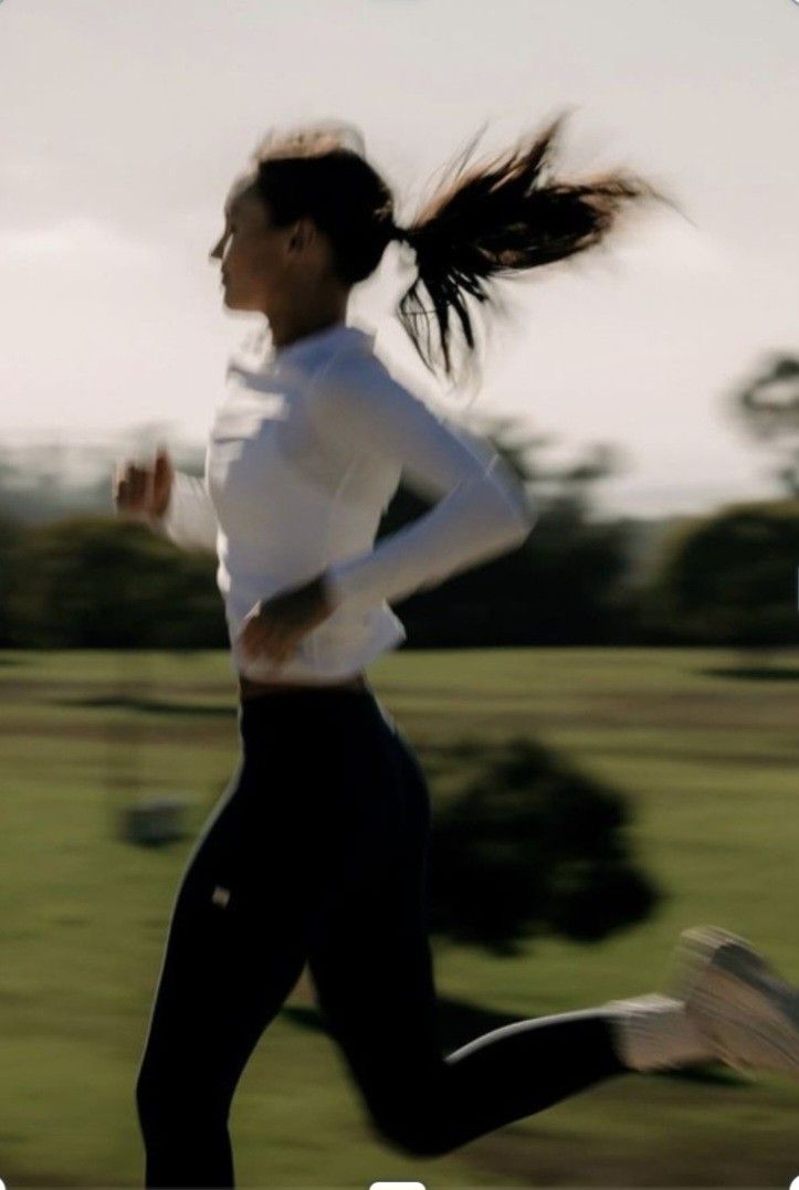 Woman running outdoors in performance activewear wearing DQ FITNESS ON athletic socks